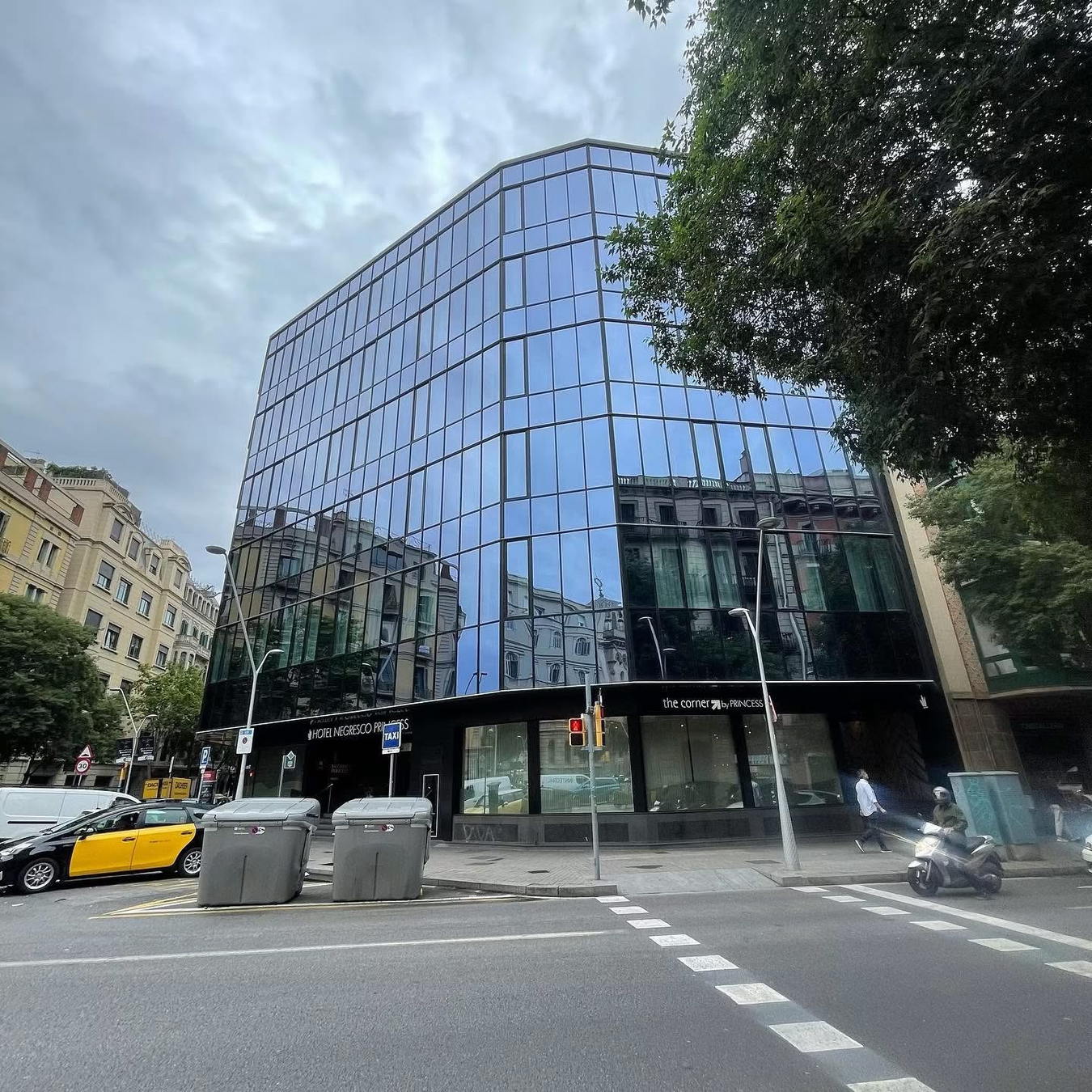 Edificio de oficinas con fachada curva de vidrio en una calle urbana