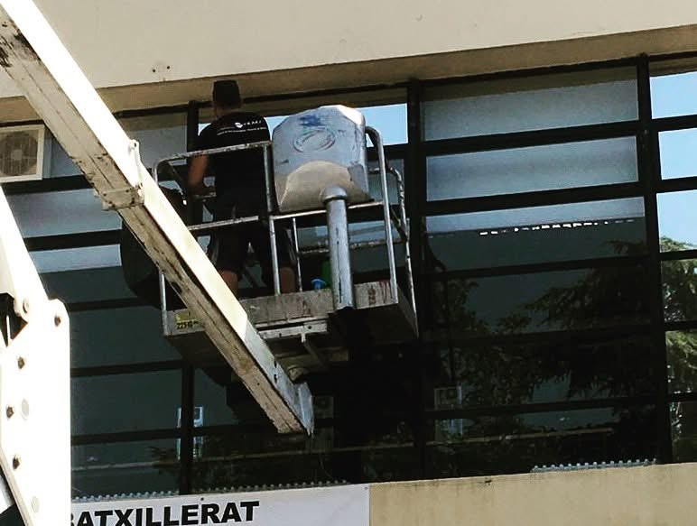 Técnicos trabajando desde plataforma elevadora en un cerramiento acristalado
