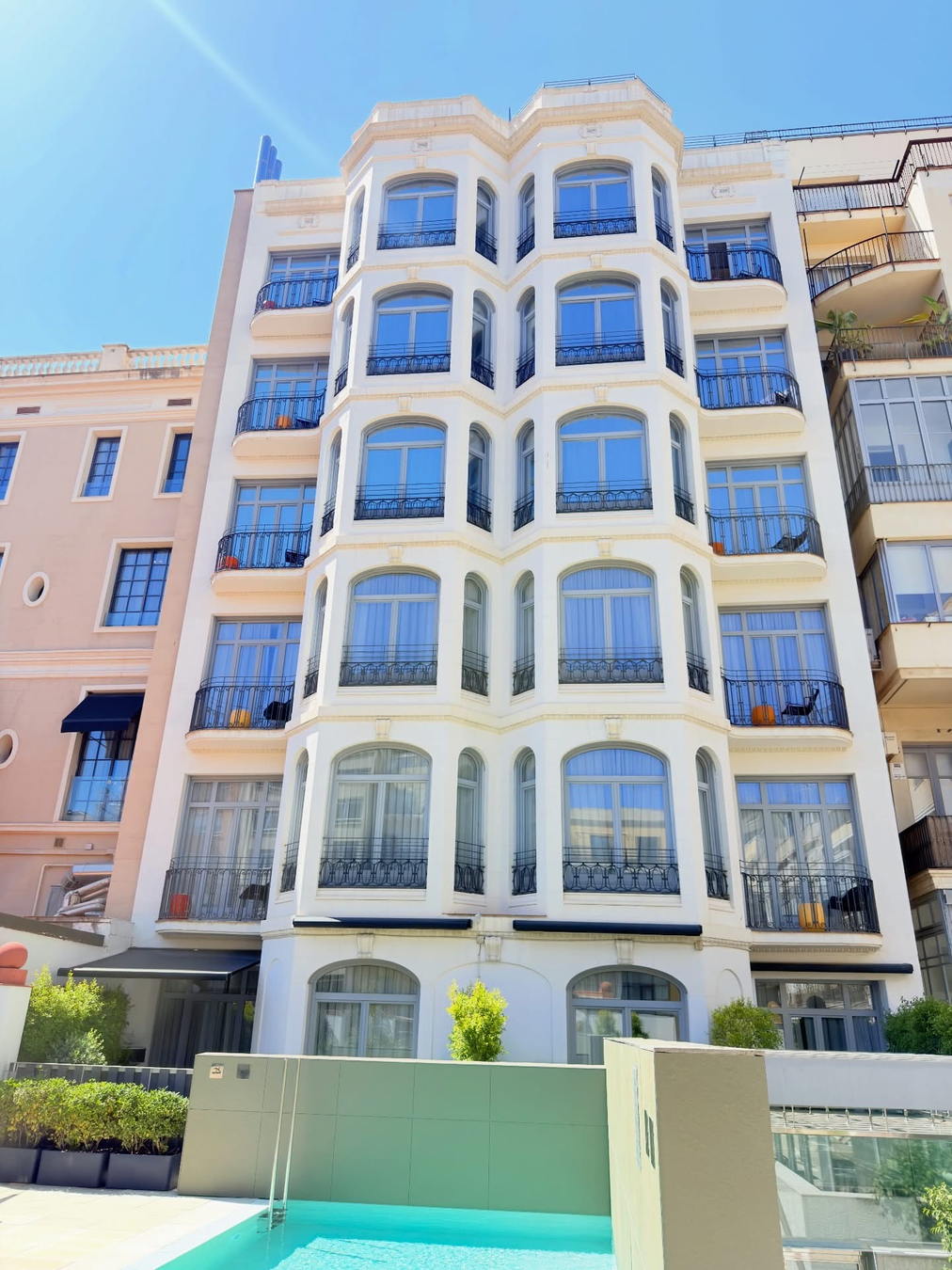 Fachada de edificio residencial de varias alturas con balcones acristalados
