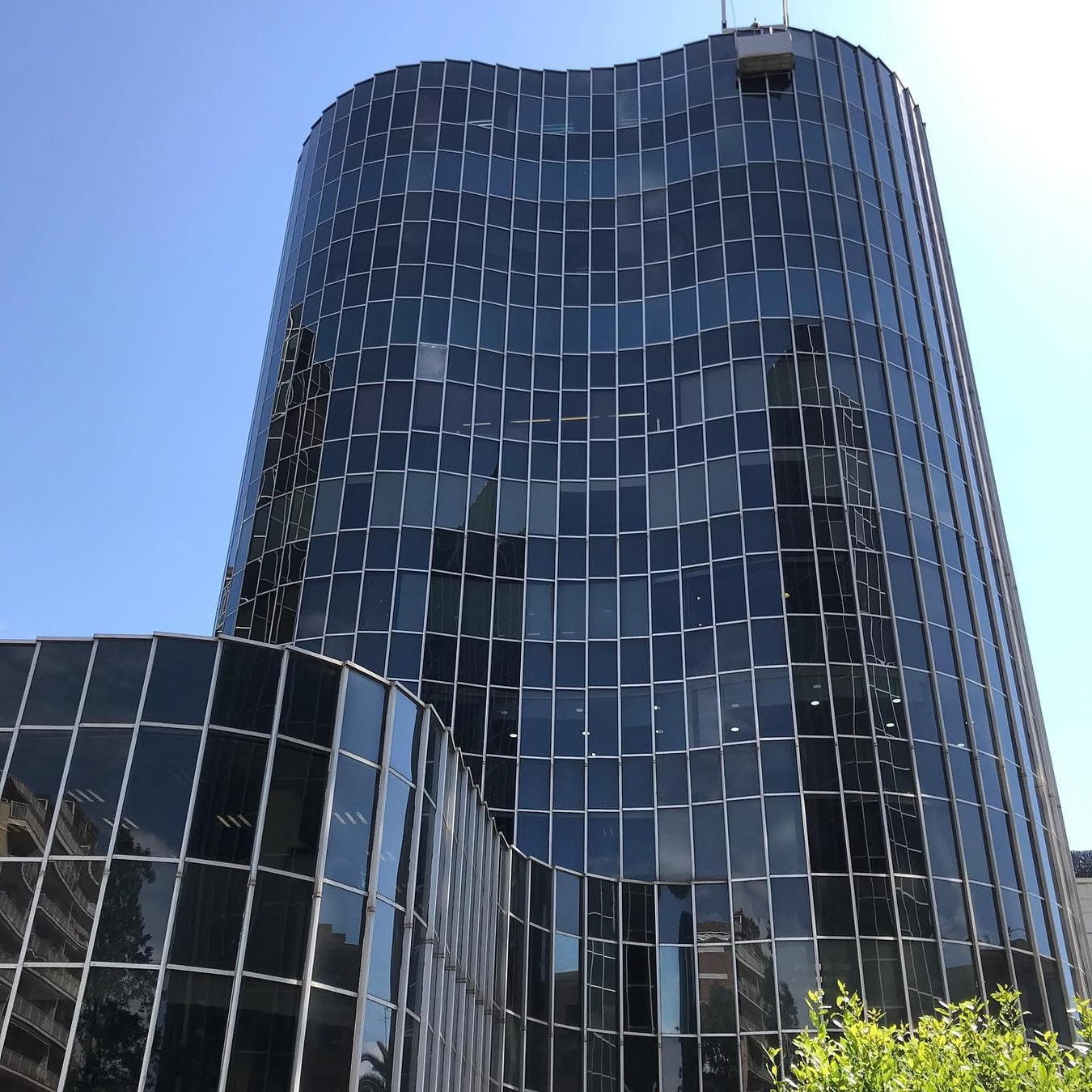 Torre acristalada de oficinas con fachada de vidrio reflectante