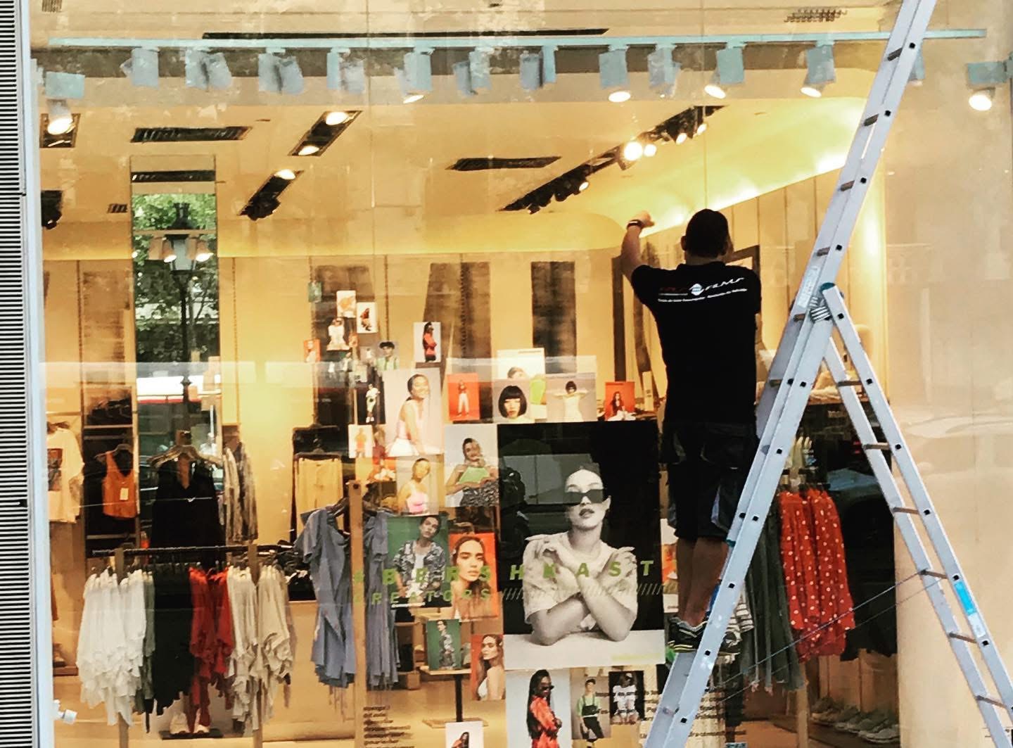 Profesional instalando una lámina transparente en el escaparate de Framas